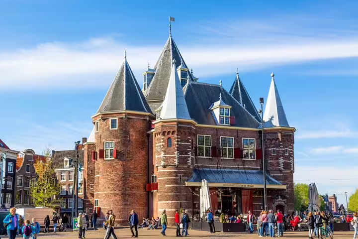 De Waag historic building on Nieuwmarkt square Amsterdam with tourists walking around