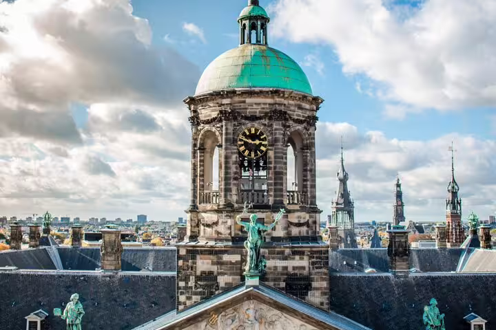 Amsterdam Royal Palace clock tower dome with green copper roof and city skyline views