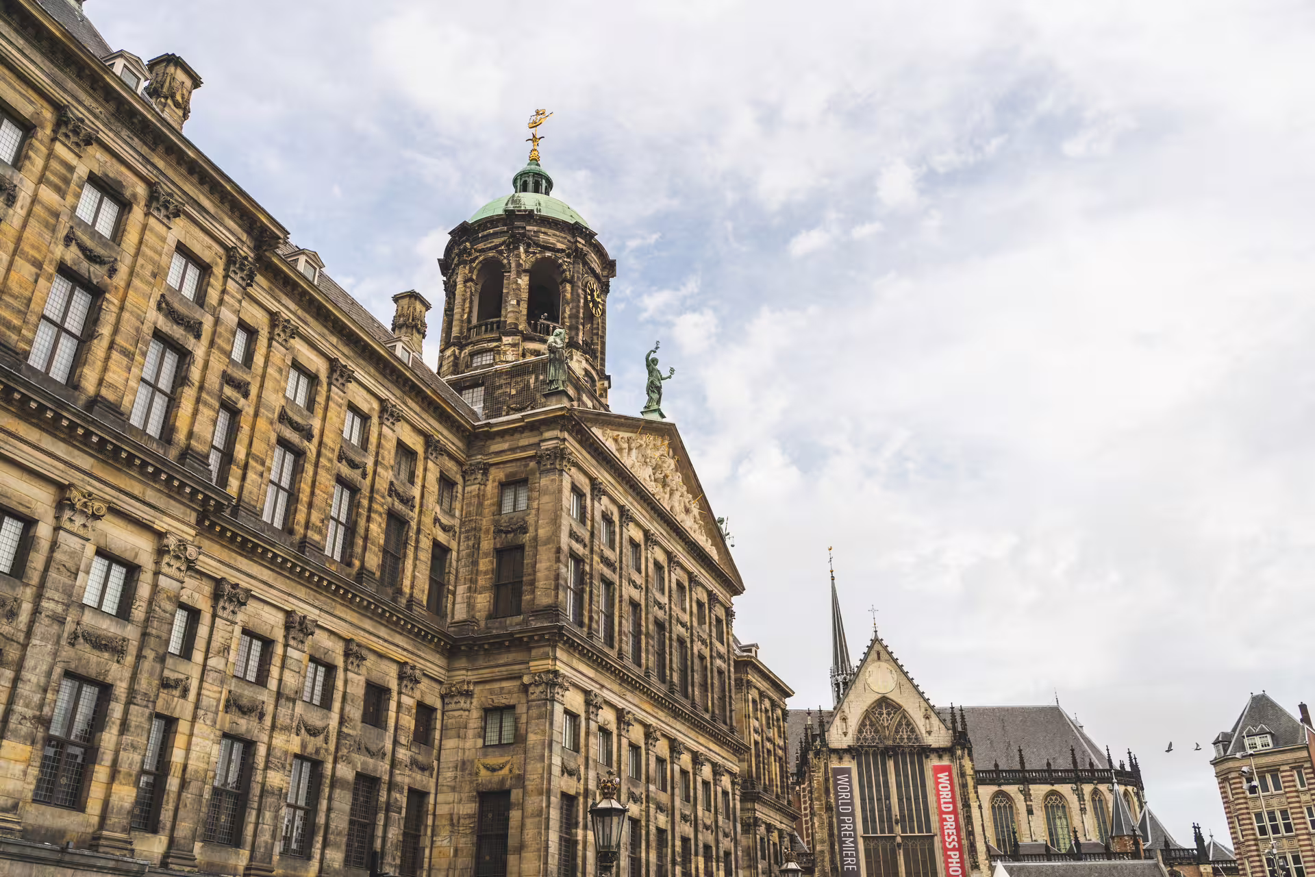 Historic Royal Palace of Amsterdam on a cloudy day, featured in walking tour with Dutch pancake lunch experience.