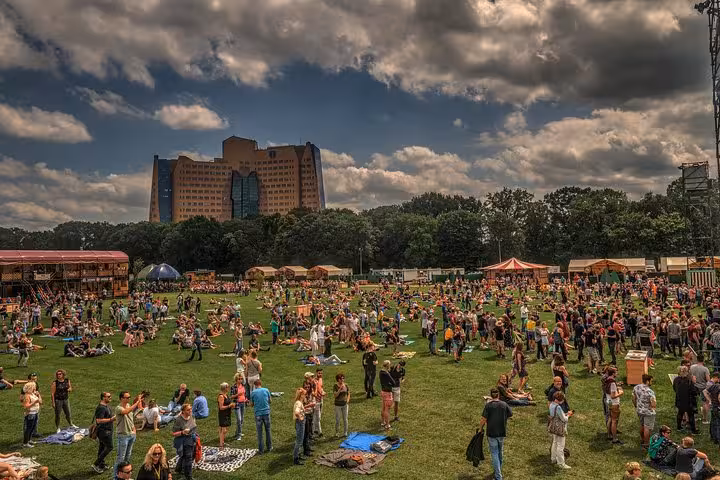 Outdoor festival crowd in city park, convenient Amsterdam or Schiphol Airport to Groningen private transfer option