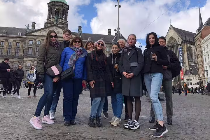 Tour group in Amsterdam city center near Dam Square, exploring hidden gems with tastings and PDF guide