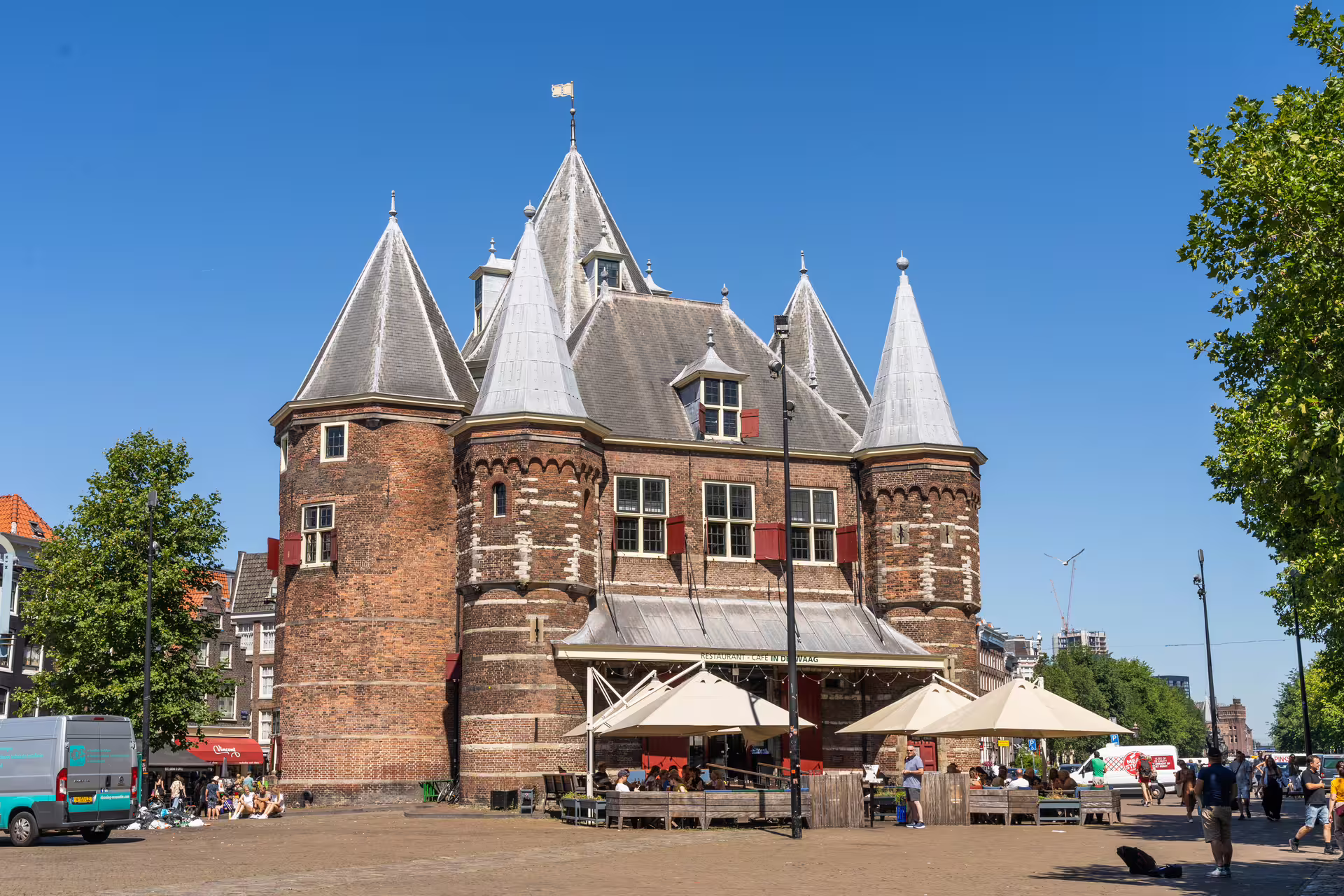 Medieval Waag building in Amsterdam under clear blue sky, highlighting a popular stop on the walking tour with canal cruise.