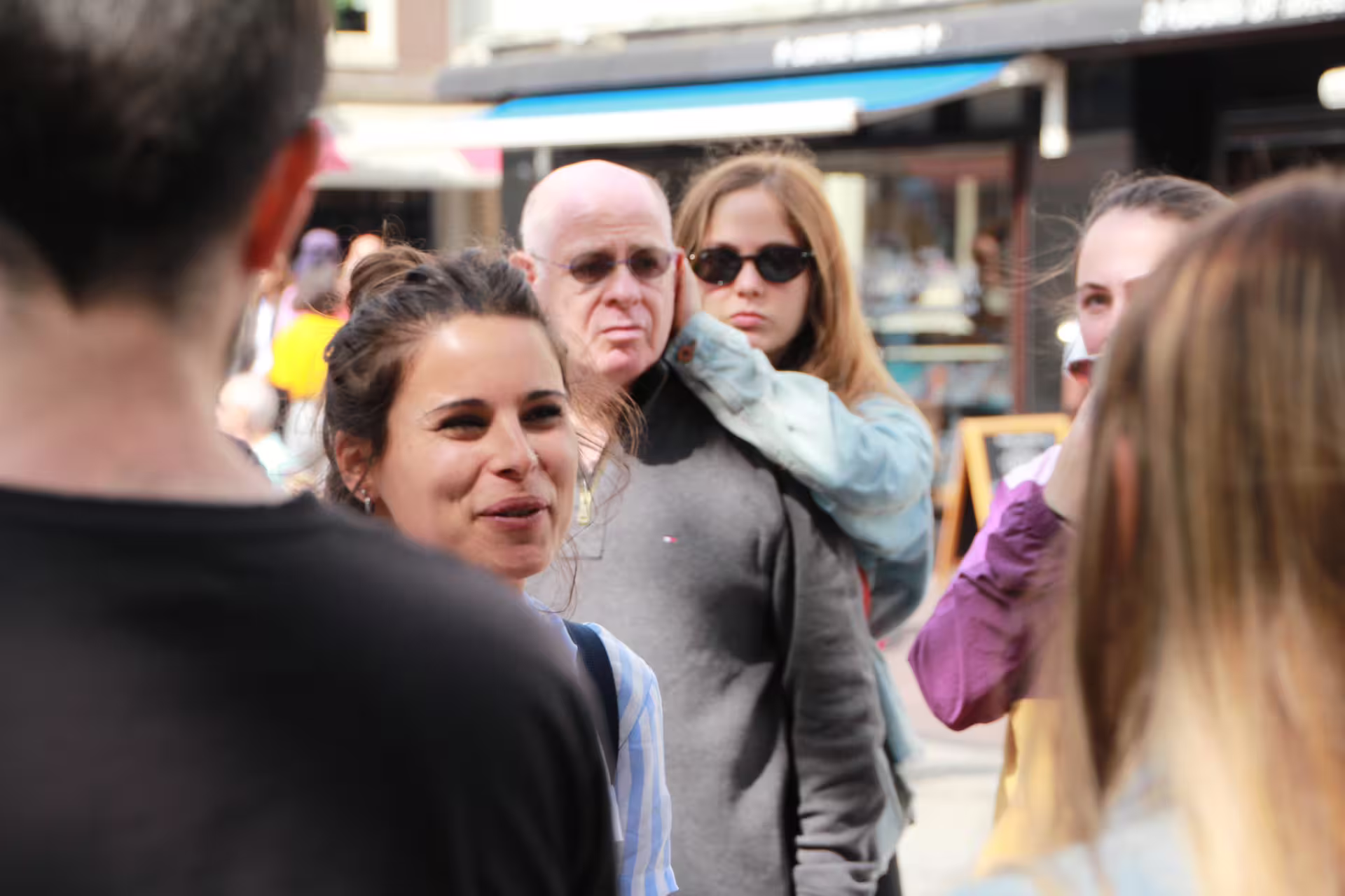 Tour guide engaging with a small group during an Amsterdam walking tour, highlighting local culture and vibrant street life.