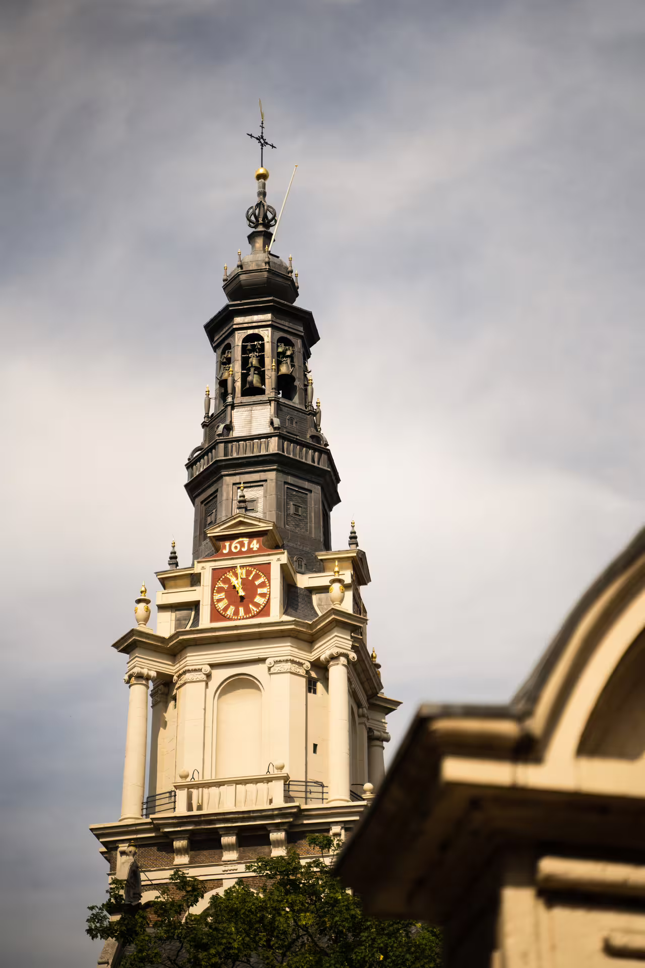 Historic Westerkerk tower against a cloudy sky, a highlight on the Amsterdam walking tour with cheese tasting experience.
