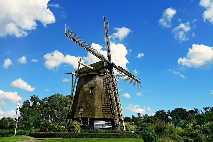 Traditional Dutch windmill under clear blue sky, a scenic highlight on a private 2-hour Amsterdam sightseeing tour.