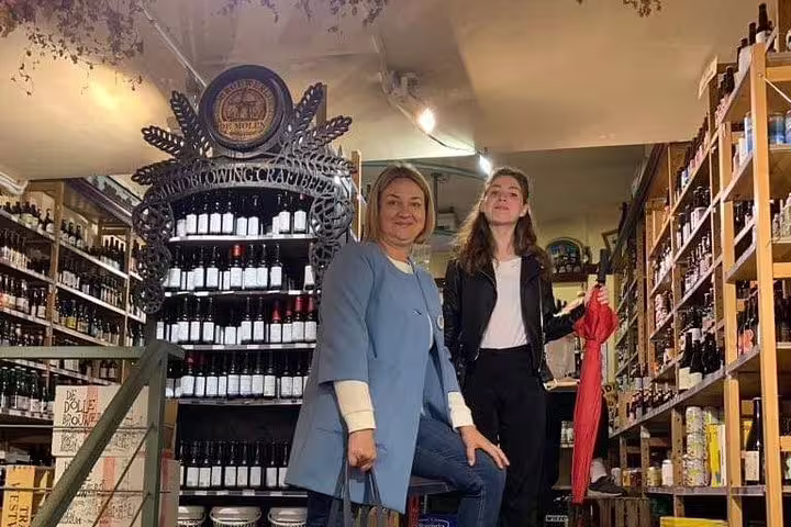 Guests inside Amsterdam wine shop tasting Dutch specialties on a private walking food tour in the city center