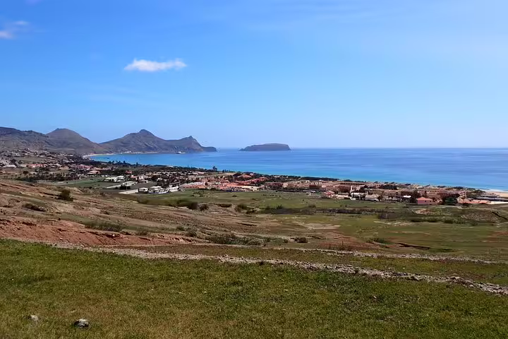 Scenic view of Porto Santo Island's coastline with lush landscapes and distant peaks, perfect for the Ana Ferreira Caves & Peaks Trek.