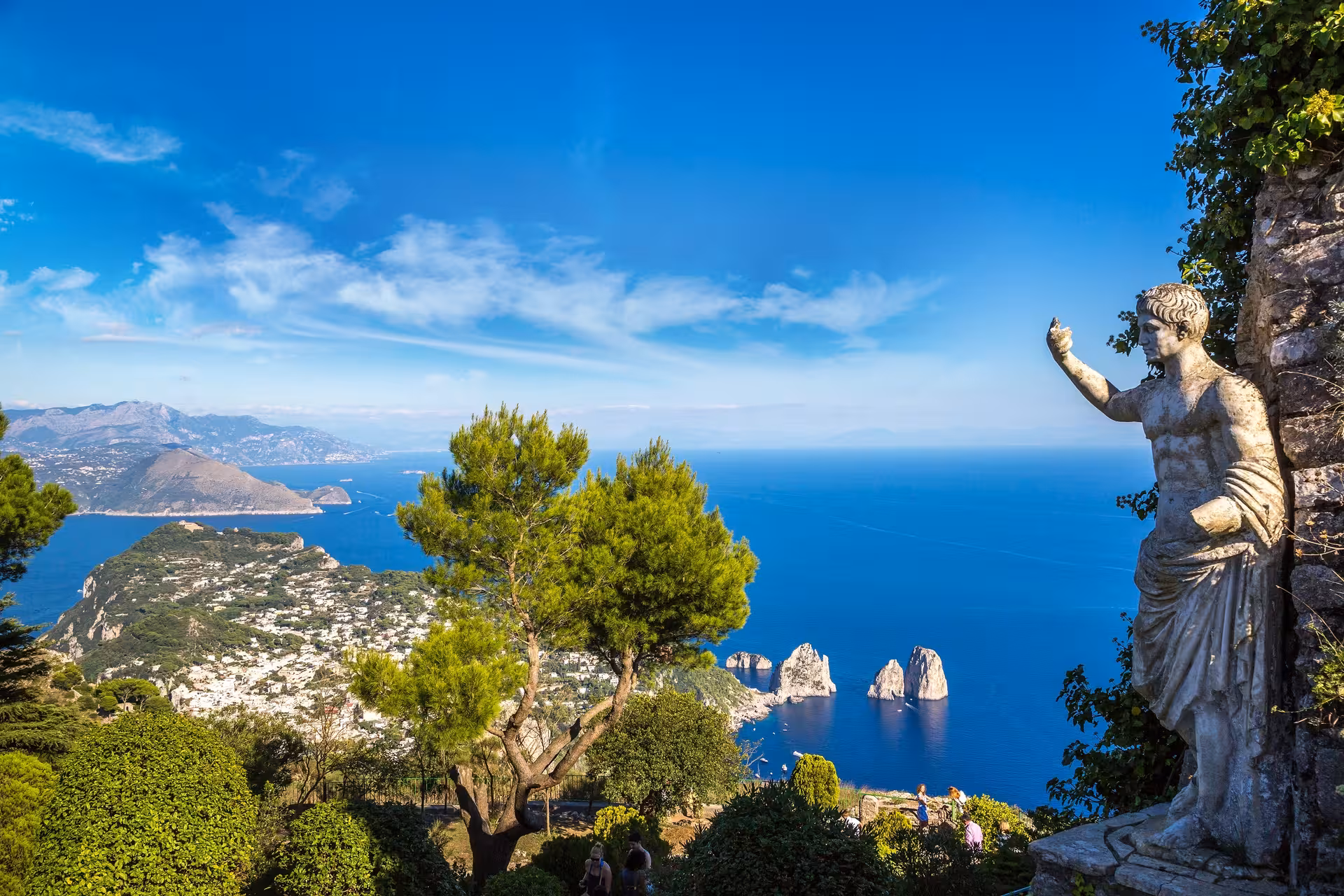 Panoramic view from Anacapri featuring a statue overlooking the stunning cliffs and azure sea of the Mediterranean.