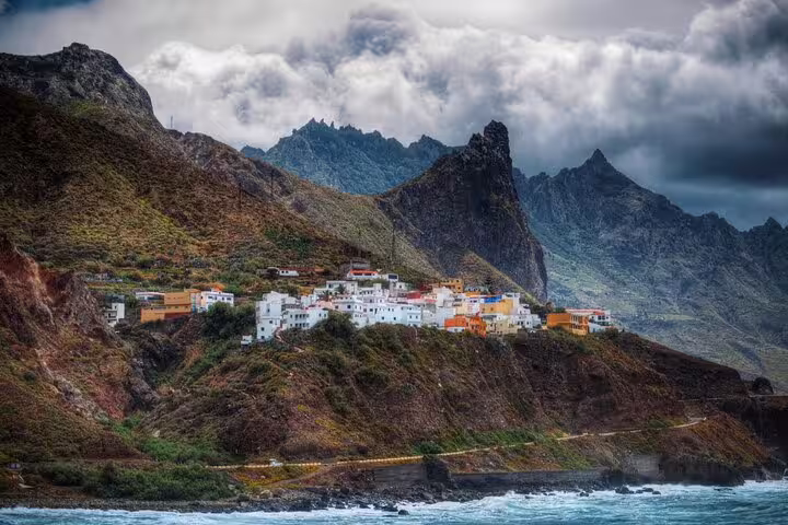Scenic view of Anaga Tenerife with dramatic mountains, a coastal village, and vibrant sea, ideal for nature tours.
