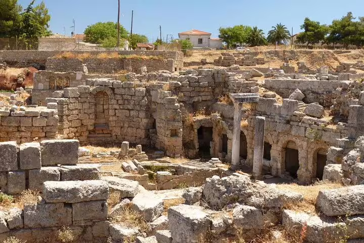 Ancient Corinth ruins with stone arches and columns, key stop on private biblical tour from Athens