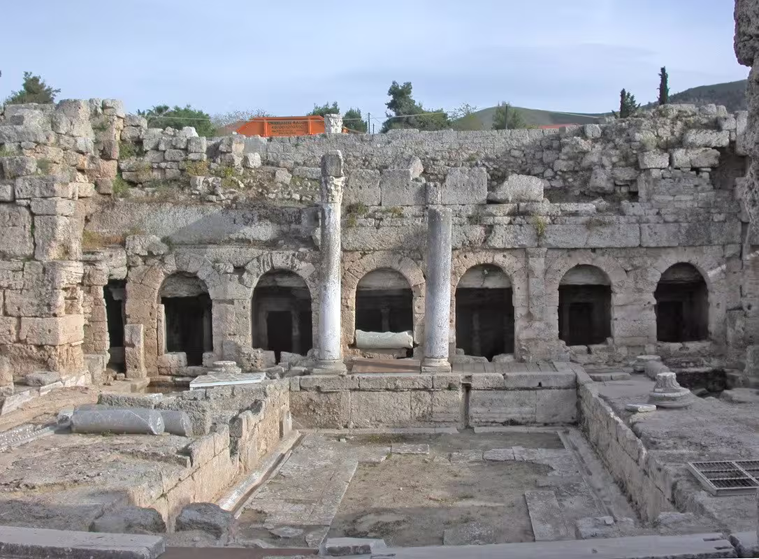 Arched stone ruins and columns at Ancient Corinth archaeological site on a private guided tour from Athens