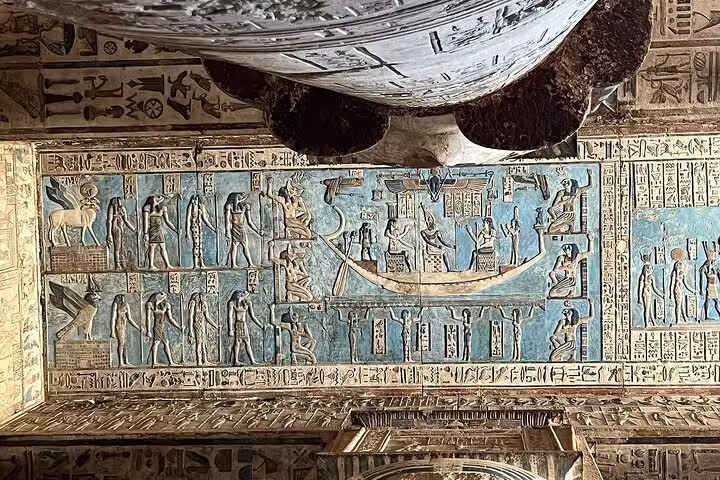 Vividly painted ancient Egyptian mural in Luxor's West Bank, depicting gods and a celestial boat scene.