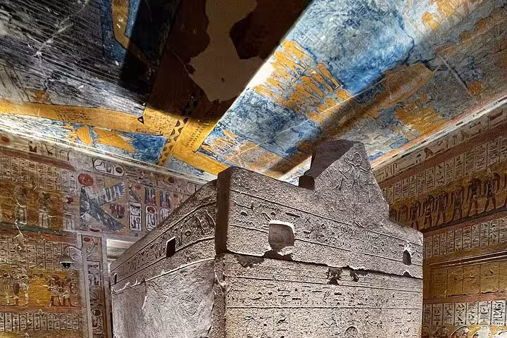Ancient Egyptian sarcophagus surrounded by colorful hieroglyphics, displayed in the West Bank Luxor tour.