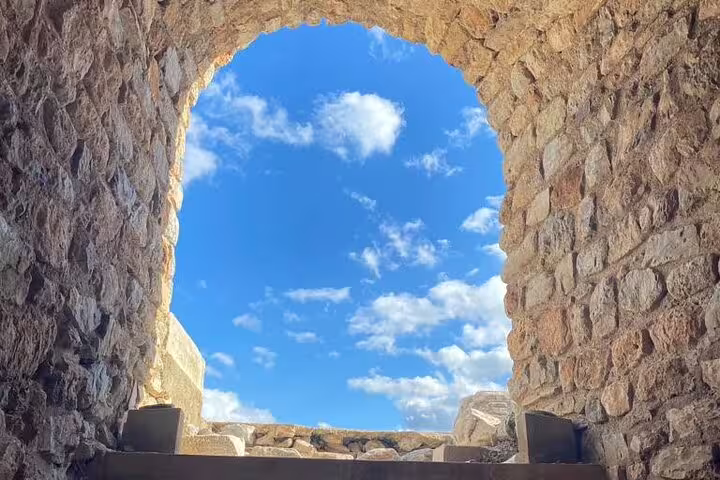 Stone archway framing blue sky at ancient Ephesus ruins on a private less-walking tour from Kusadasi