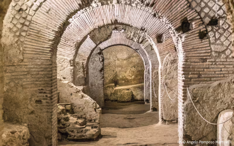 Arched brick tunnels of the Ancient Naples Buried Path, revealing Roman ruins on an underground archaeology tour