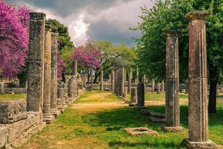 Ancient Olympia archaeological site columns and pathway, scenic stop on private transfer from Athens to Olympia