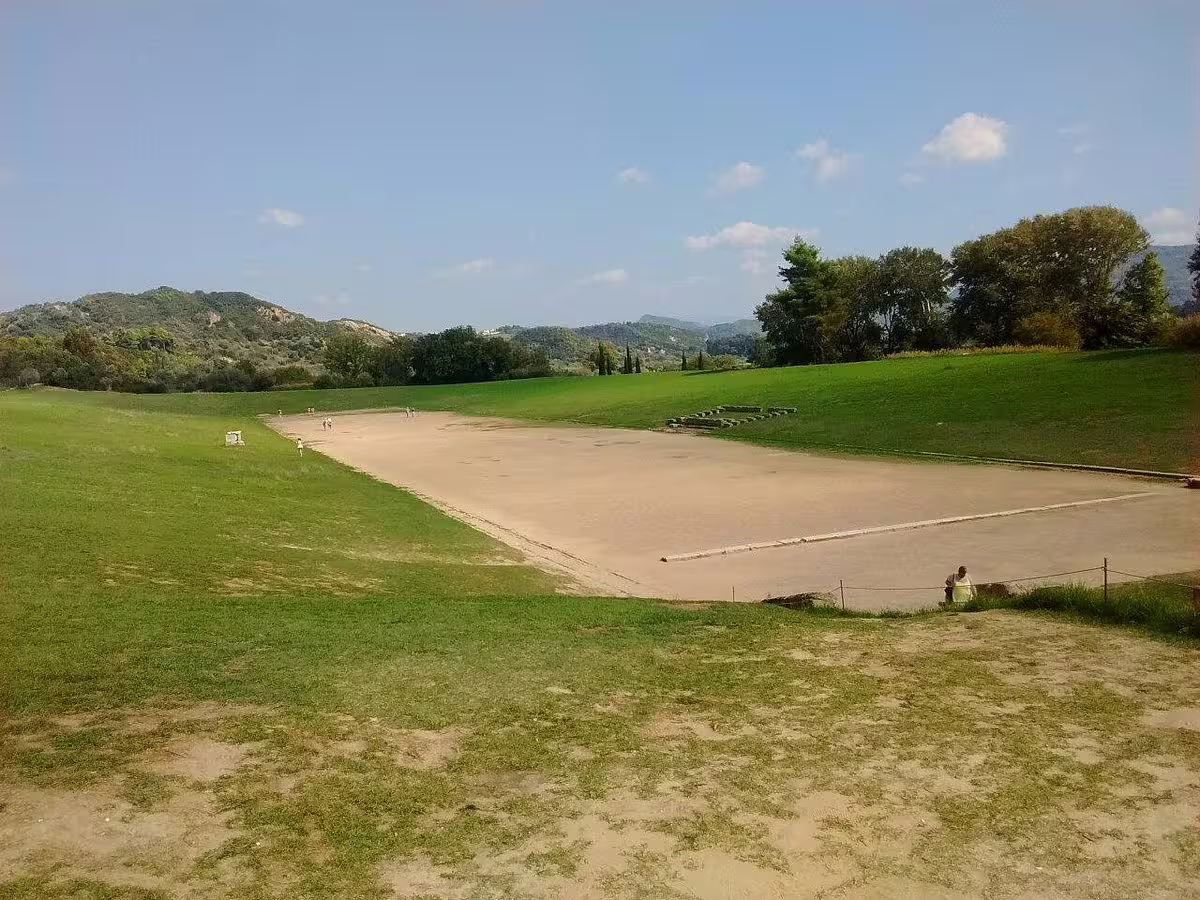 Ancient Olympia stadium track view on private tour from Athens, historic Olympic site with green hills