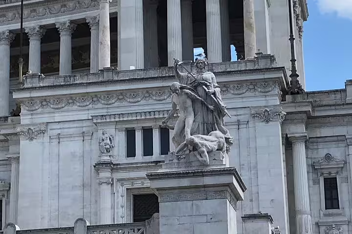 Classical marble sculptures on the facade of an ancient Roman monument with ornate columns