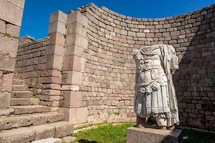 Ancient statue amidst stone ruins at Pergamon, showcasing classical architecture on the Pergamon & Asceplion tour.
