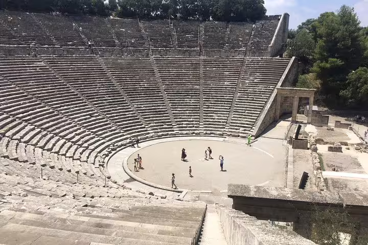 Ancient Theatre of Epidaurus with stone seats and visitors on stage, Epidaurus Mycenae Nafplio tour from Athens