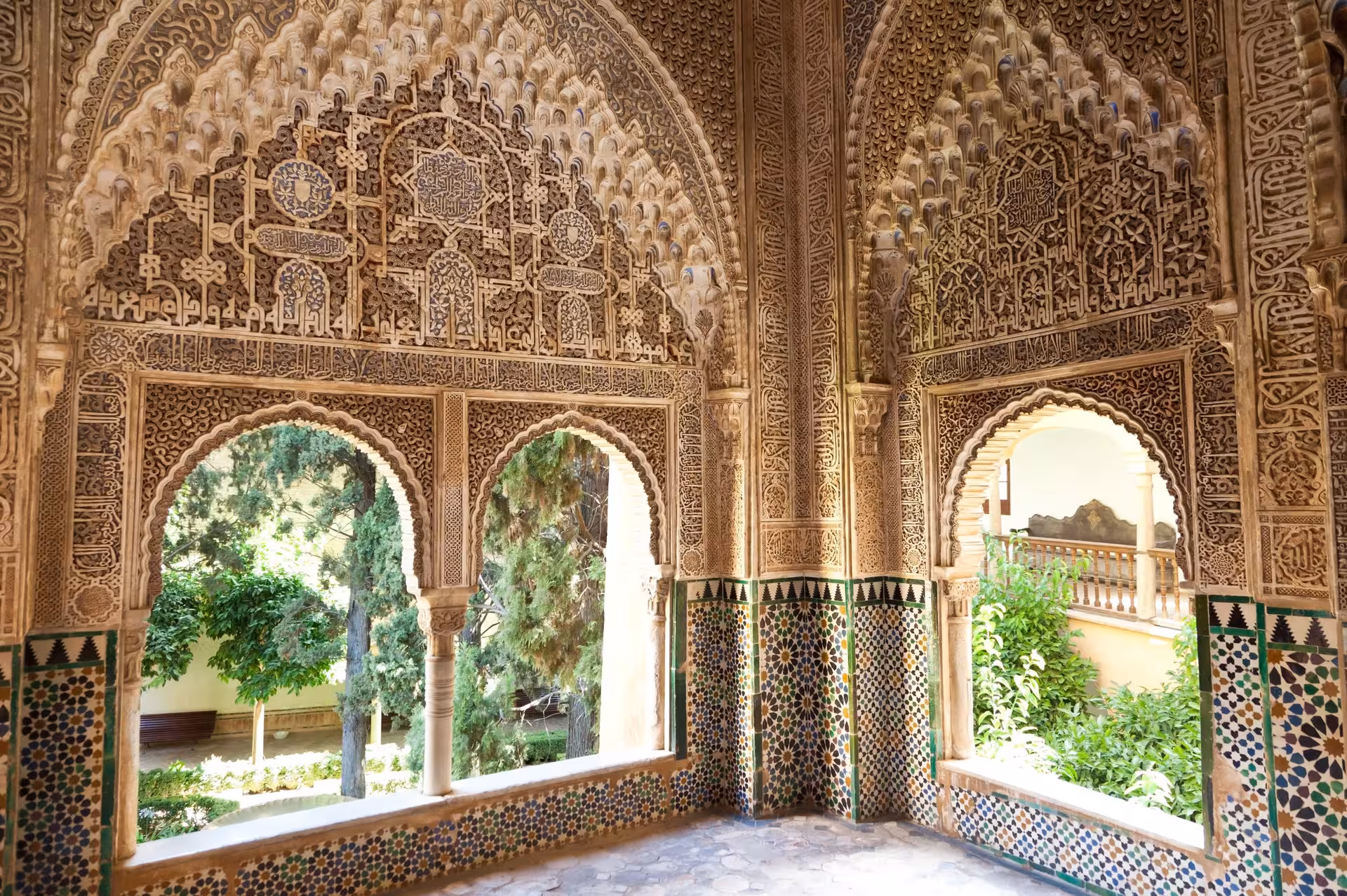 Intricate Moorish architecture in Andalusia's Alhambra Palace, highlighting elaborate arches and decorative tiles.