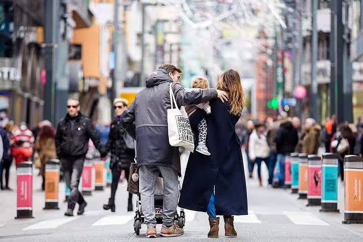 Family strolling along a bustling Andorra shopping street, perfect for sightseeing and traditional lunch on a private tour.