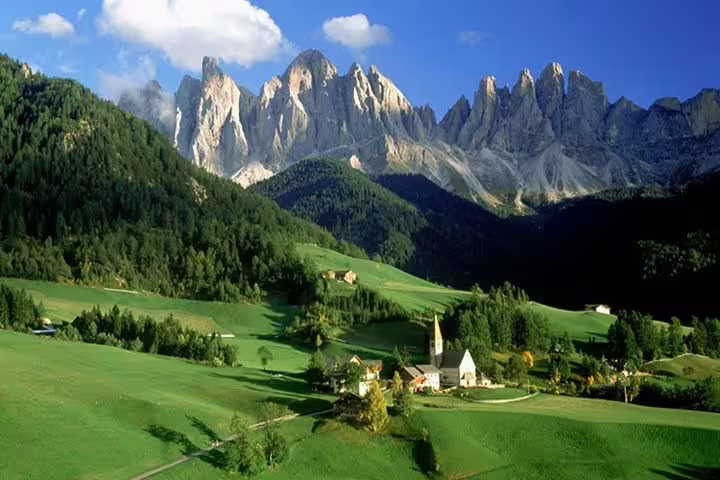 Scenic Andorra landscape with lush green valleys, dramatic mountain peaks, and quaint village architecture.