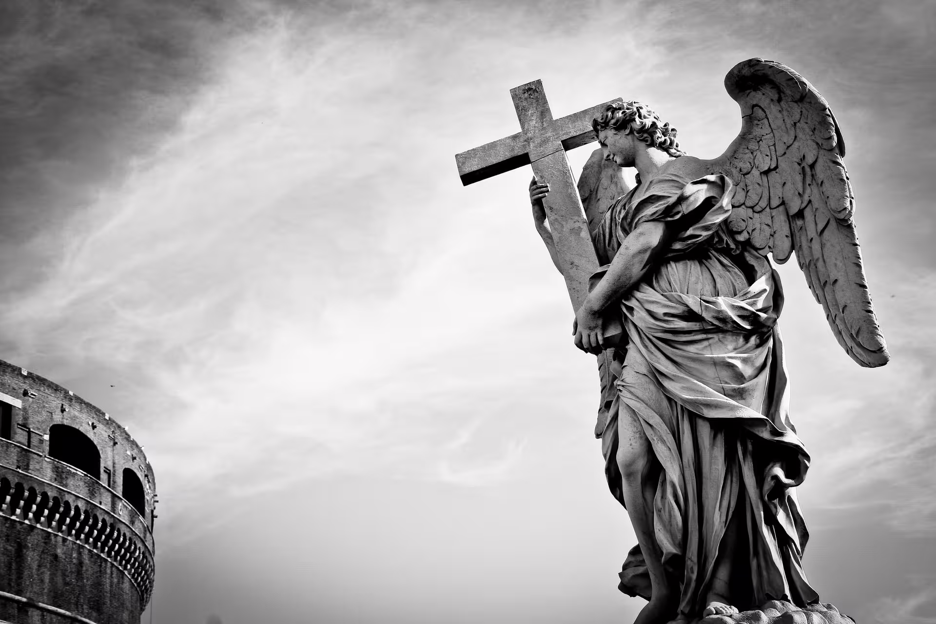 Black and white angel statue with cross near Castel Sant’Angelo on atmospheric Ghosts of Rome night tour