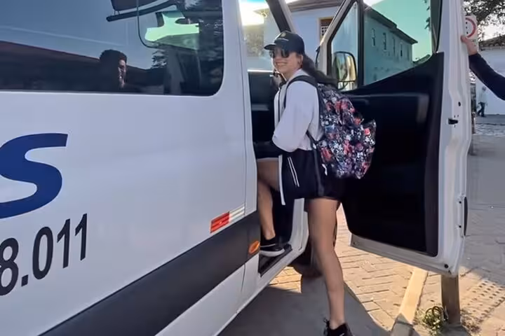 A traveler stepping into a Paraty Tours van, ready for a transfer from Angra dos Reis to Rio de Janeiro.