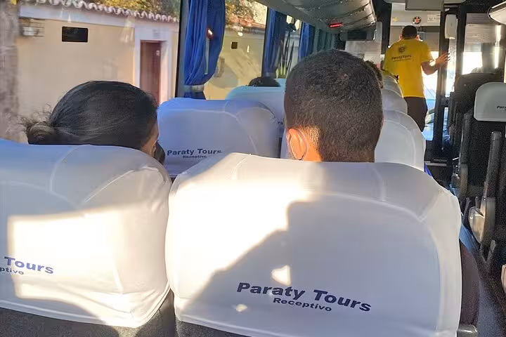 Passengers sitting inside a Paraty Tours van during a shared transfer from Angra dos Reis to Rio de Janeiro.