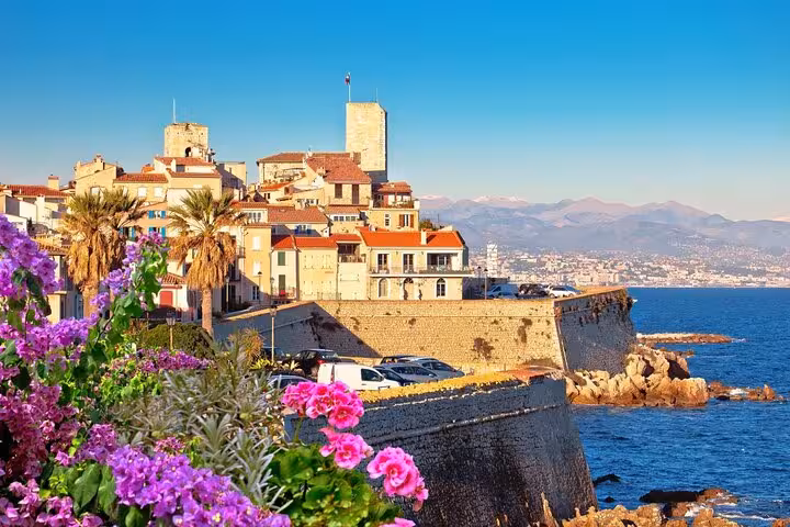 Scenic coastal view of Antibes with vibrant flowers and historic architecture on Provence tour.