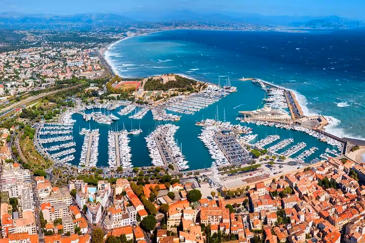 Aerial view of Antibes marina with yachts, turquoise Mediterranean Sea, and coastal cityscape in South of France