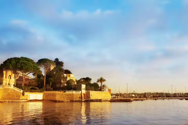 Golden hour view of Antibes marina on the Cote d’Azur, French Riviera waterfront with yachts and villas