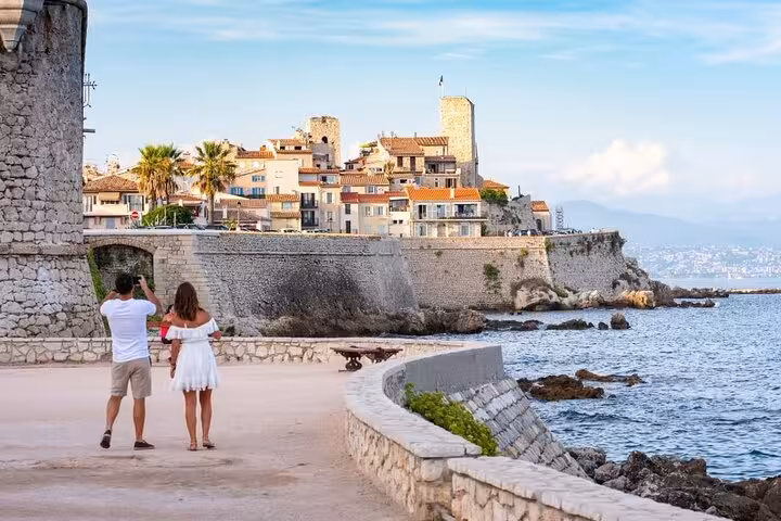 Couple photographing the historic old town walls and coastline of Antibes on the French Riviera