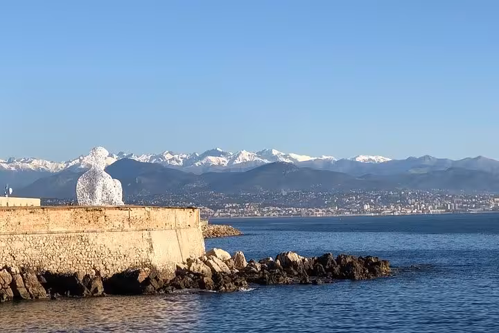 White sculpture on Antibes stone ramparts overlooking the Mediterranean Sea and snow-capped Alps