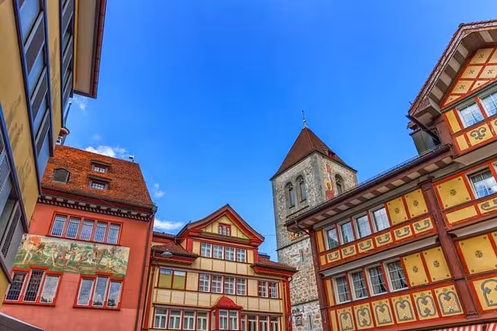 Colorful historic buildings and tower in the heart of Appenzell, showcasing traditional Swiss architecture under a clear sky.