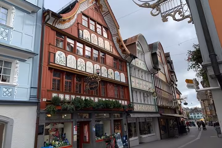 Charming painted facades of traditional Swiss buildings along a quaint street in Appenzell, perfect for cultural exploration.