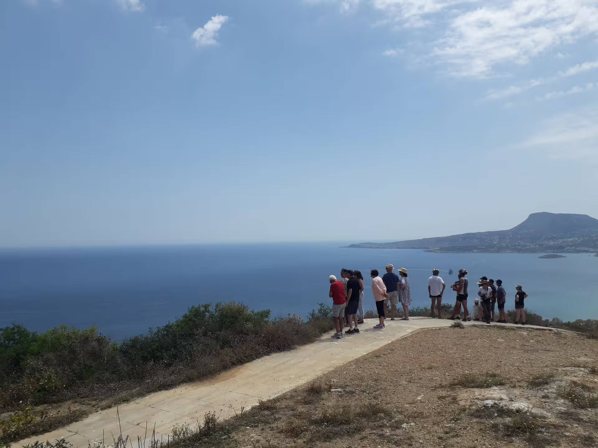 Tourists enjoy panoramic views of the sea and landscape from a scenic viewpoint on the Aptera & Chania tour.