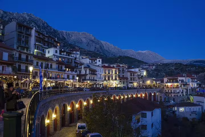 Arachova village at dusk near Delphi, stone bridge lights and mountain views on private tour from Athens