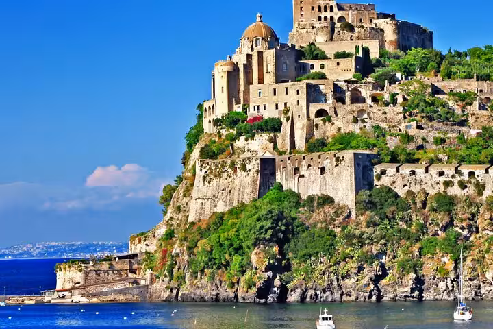 The iconic Aragonese Castle on Ischia Island, majestically rising above the sea, a highlight on the full-day boat tour from Naples.