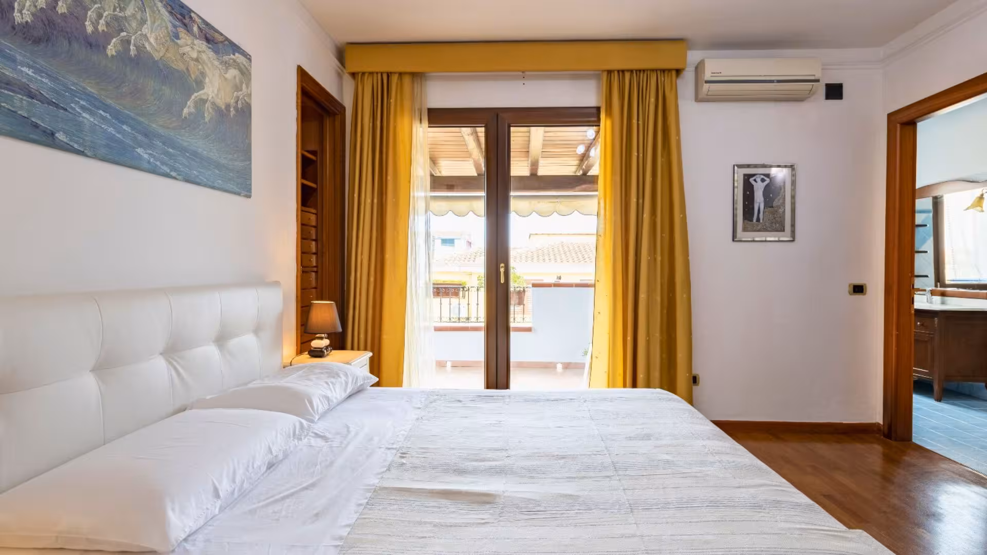 Bright bedroom with balcony access in Arbatax, perfect for relaxing after a day of trekking the Selvaggio Blu.
