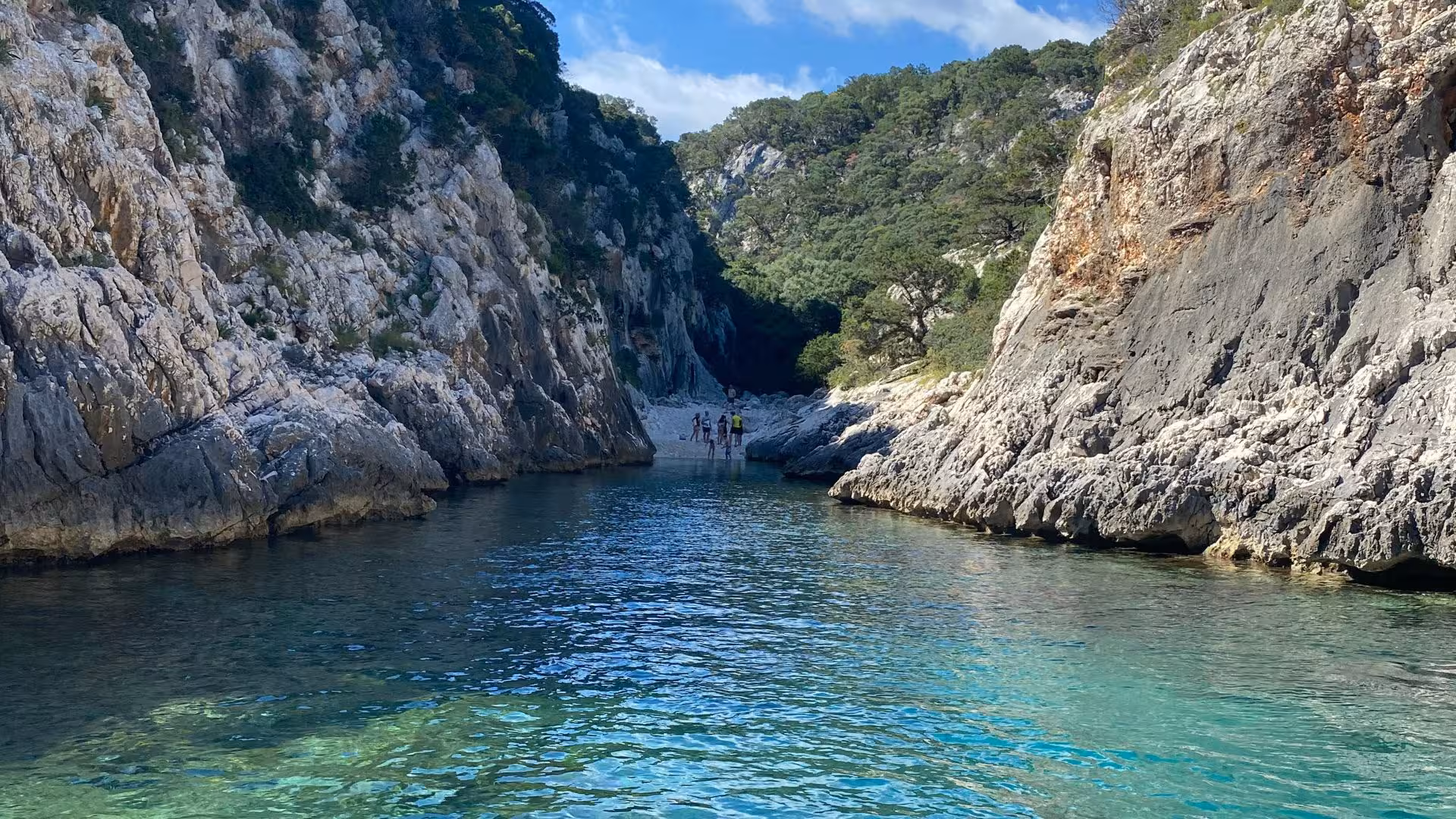 Scenic view of a tranquil inlet with clear turquoise waters surrounded by rocky cliffs on the RIB trip from Arbatax.