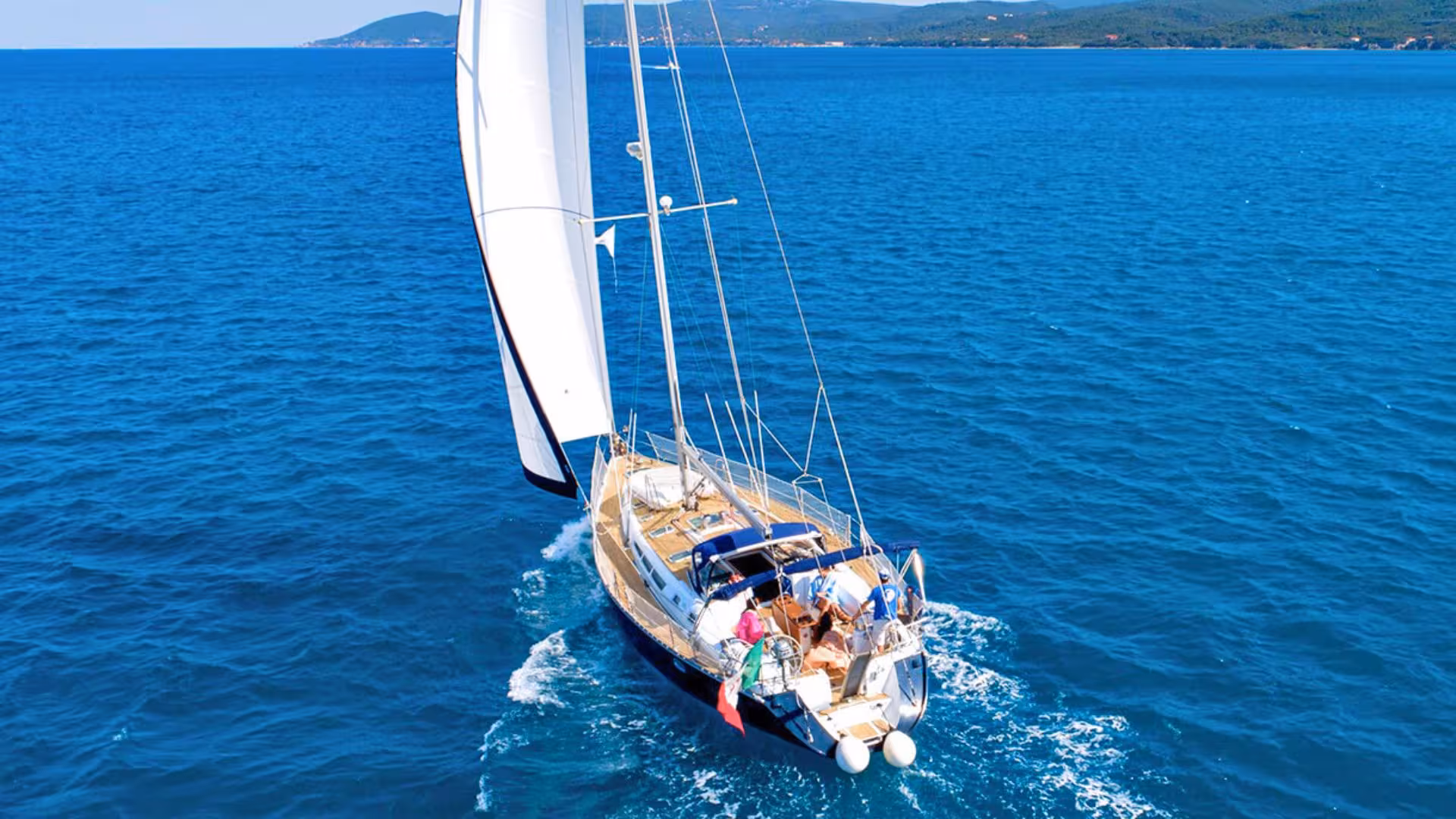 Elegant sailboat cruises through the vibrant waters of the Gulf of Orosei on a scenic Arbatax sailing tour.