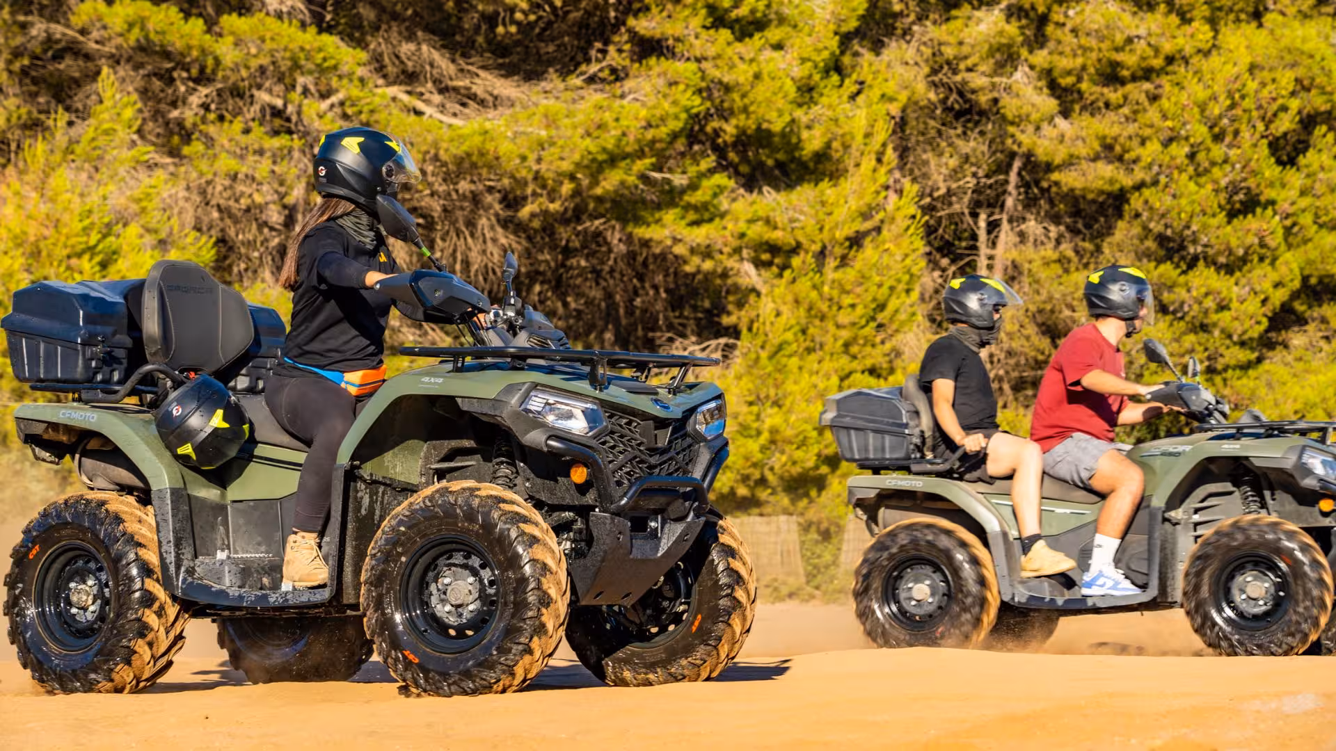 Group enjoying an ATV ride through sandy trails on Arbus excursion, surrounded by lush greenery.