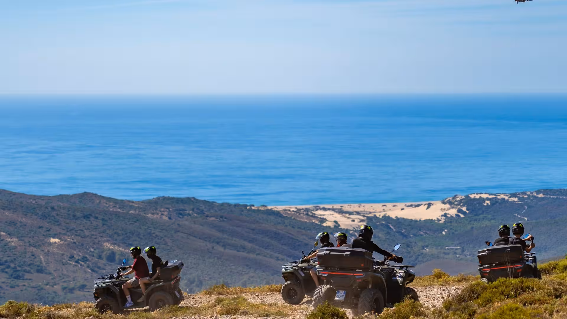 Riders on ATVs enjoy breathtaking views of Costa Verde's coastline and rolling hills during an Arbus tour.