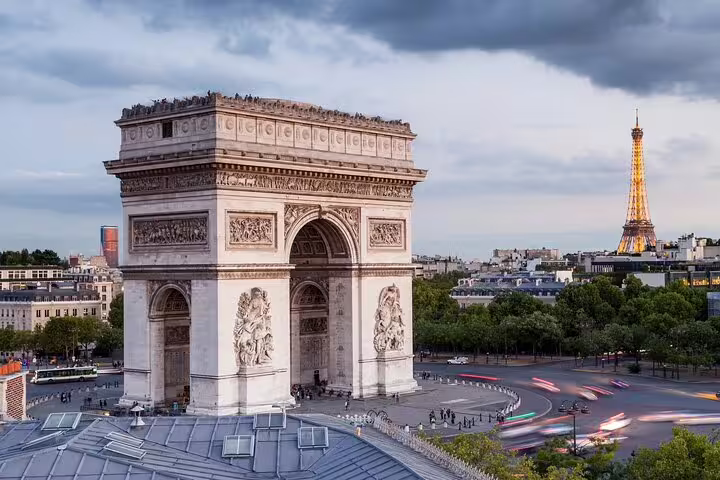 Arc de Triomphe with Eiffel Tower illuminated in background, Paris city view at dusk