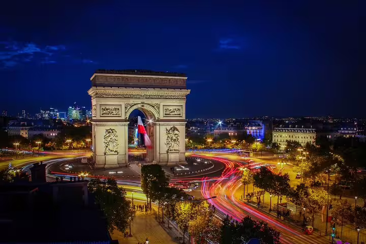 Arc de Triomphe at night with light trails from traffic on Champs-Élysées, Paris