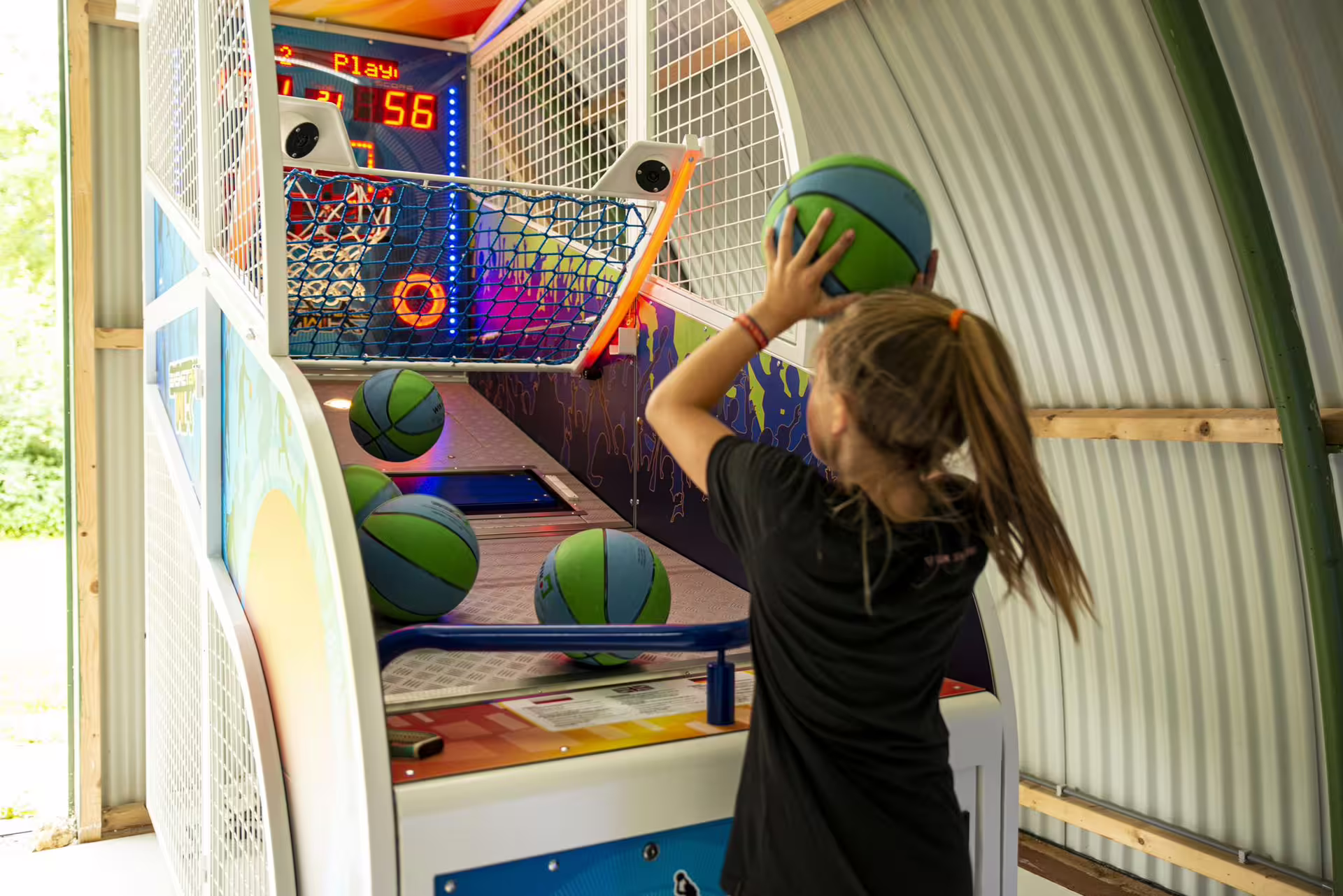 Player shooting hoops on arcade basketball game at Amsterdam arcade hall, ideal for group events and parties