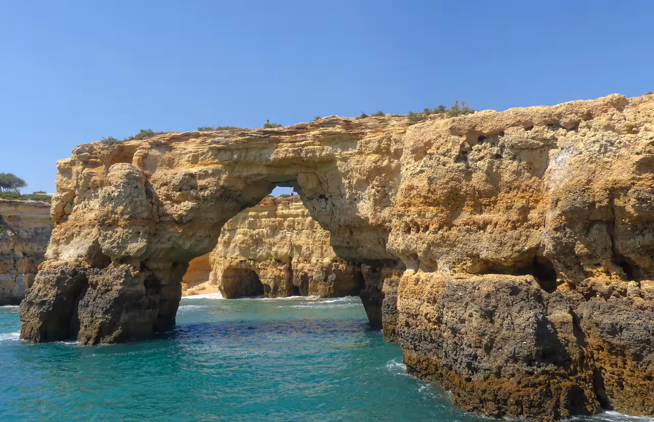 Stunning natural rock arch and sea caves along the Algarve coastline near Benagil seen from a boat tour