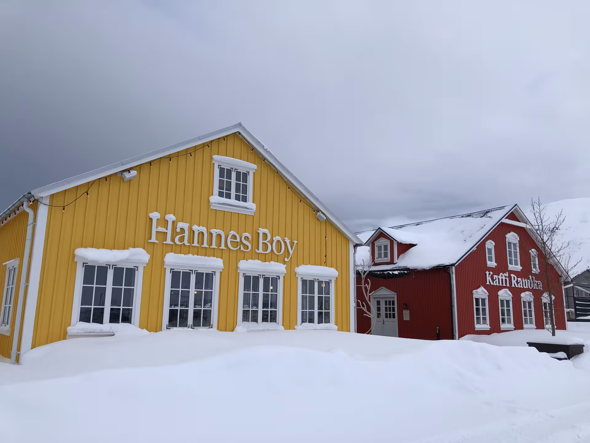 Snow-covered traditional Arctic buildings in vibrant colors, highlighting cultural heritage and winter scenery.